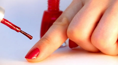 mujer poniendose esmalte de uñas